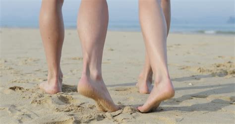 female legs standing by the sea on the beach stock footage
