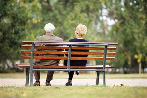 rear view of a senior couple sitting outdoor on bench circle of care