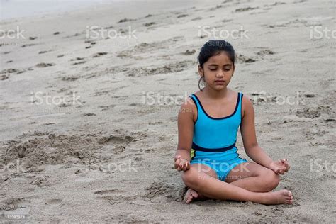 small indian girl on konkan beach sand doing yoga horizontal stock