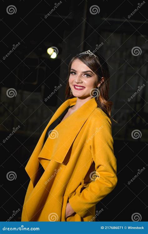 beautiful and elegant caucasian woman in a black dress and a yellow