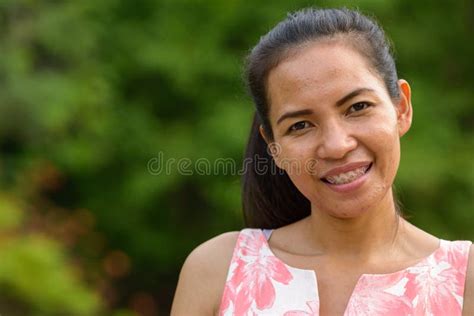 Happy Mature Asian Woman Relaxing At The Park Outdoors Stock Image