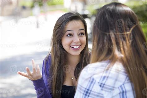 Expressive Young Mixed Race Female Sitting And Talking With Girlfriend