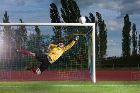 full length  soccer goalkeeper diving  block ball stock photo