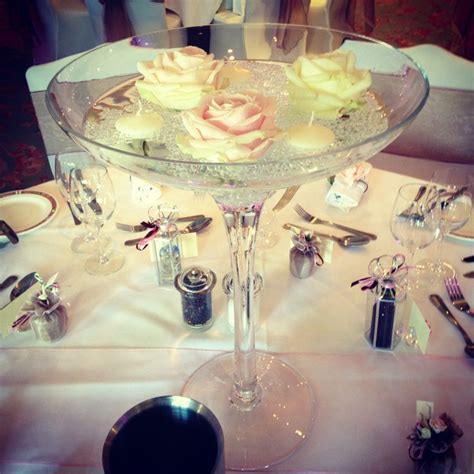 Avalanche Roses With Floating Candles In A Champagne Glass Centre Piece