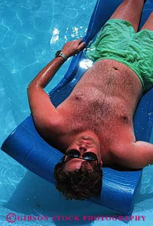 released man sunbath float pool stock photo