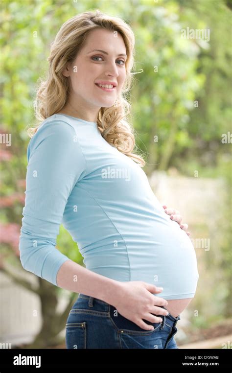 pregnant female wavy blonde hair wearing a blue top long