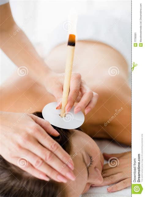 masseur giving ear candle treatmet to woman stock image image of