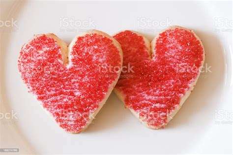 two valentine red heart sugar frosted cookies on plate closeup stock