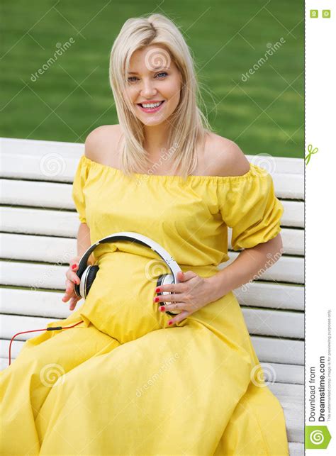 Beautiful And Pregnant Blonde Girl In A Yellow Dress Stock