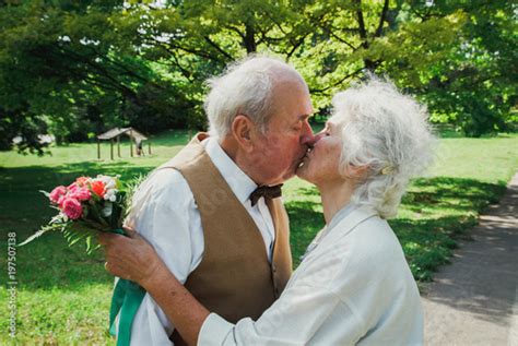 old couple is walking in the green park grandmother and grandfather at