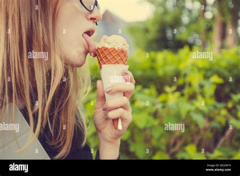 Beautiful Young Blond Woman In Glasses Holding A Vanilla Cone Ice Cream