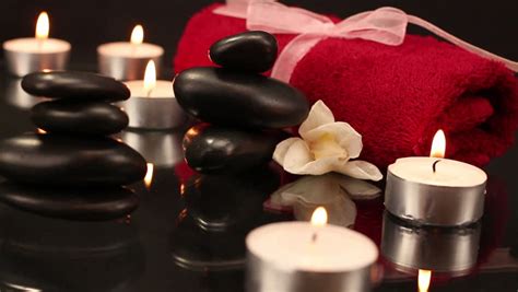 pile  black spa therapy stones surrounded  candles stock footage
