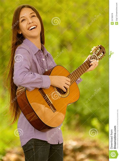 glimlachende tiener het spelen gitaar stock foto