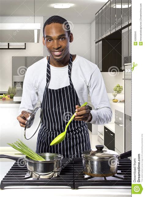 uomo che cucina ad una cucina domestica immagine stock