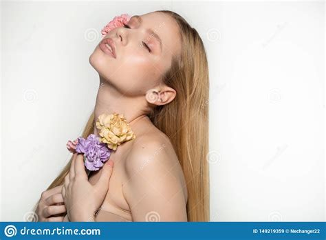 spring blonde girl with closed eyes holding flowers in