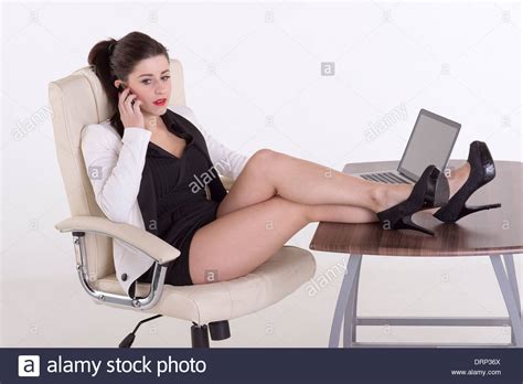 Secretary Using A Telephone Sitting At Her Desk With Her