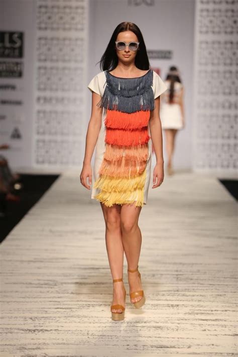 A Woman Walking Down A Runway In A Colorful Dress