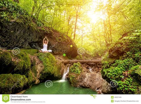woman practices yoga   waterfall sukhasana pose stock image