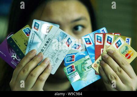 file  chinese woman shows credit cards   logos  china unionpay visa  mastercard