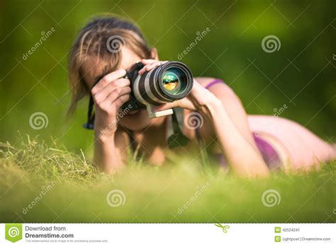 Pretty Female Photographer Lying In Grass Stock Image