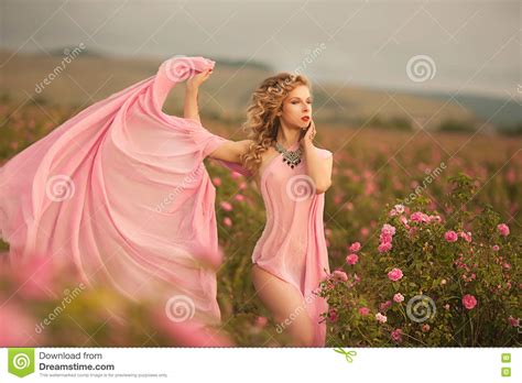 Beautiful Girl In A Pink Dress Standing In The Garden