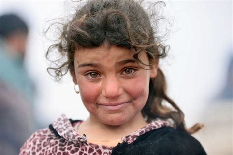 A Displaced Iraqi Girl Who Fled Her Home Smiles Through Her Tears