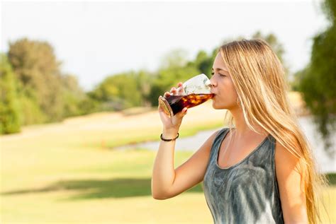 beautiful blonde woman drinking   beer glass   park   sunny day