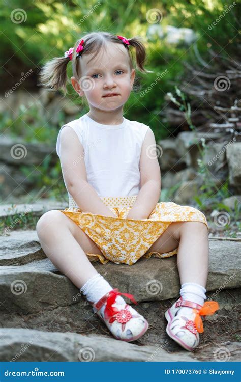 portrait   cute  girl   background  nature shes sitting   rocks stock