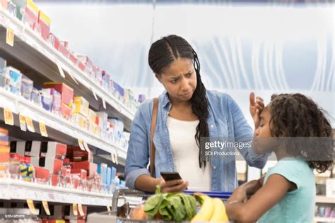 Mother Checks Daughter For Fever In Supermarket Pharmacy High Res Stock