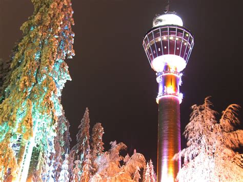 tall tower   light  top   middle  trees  snow