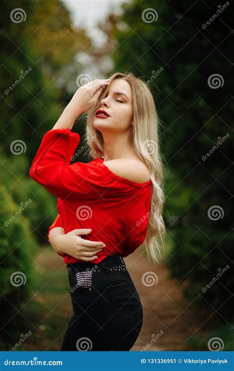 Awesome Blonde Woman In Red Blouse Posing With Naked Shoulder At Stock