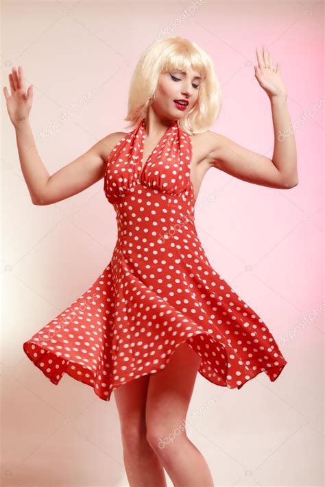 Beautiful Pinup Girl In Blond Wig And Retro Red Dress Dancing Party