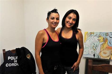 Two Women Standing Next To Each Other In A Room