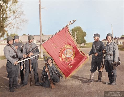 finnish soldiers showing   captured soviet flag   retaking
