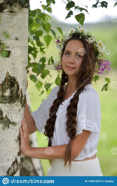 sweet russian girl girl in a white birch in the summer