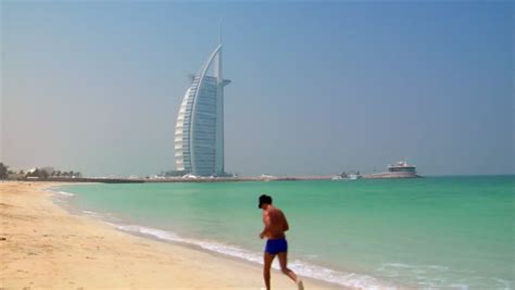 jumeirah beach with waves and people playing by the ocean