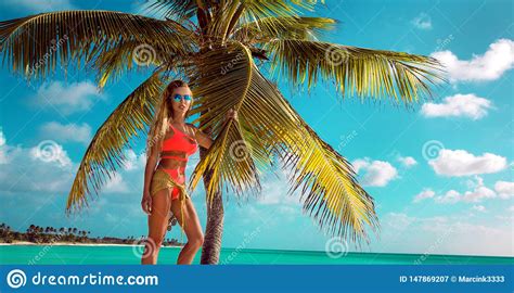 Sexy Blonde Girl On The Beach With Palms And Blue Sky