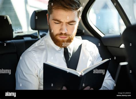 Serious Bearded Business Man Sitting On Back Seat Of A Car While