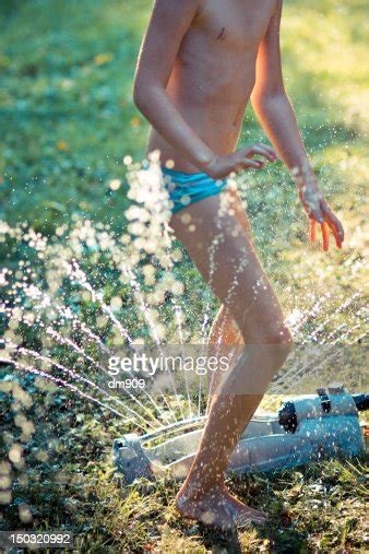 girl runs through sprinkler photo getty images