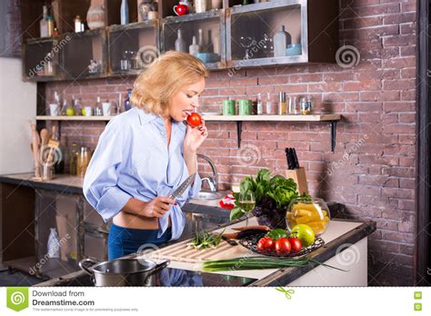 Blonde Hausfrau Lecken Geschmacktomate Auf Küche Stockfoto Bild Von