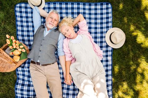 Free Photo Relaxed Elderly Couple Laying On The Grass