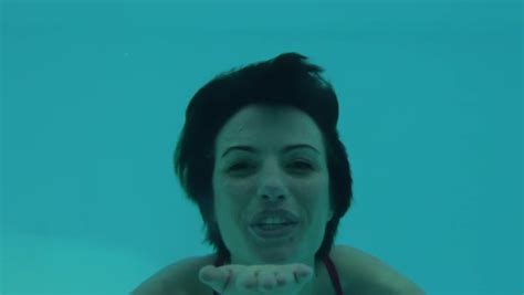 woman blowing a kiss while swimming underwater in a swimming pool