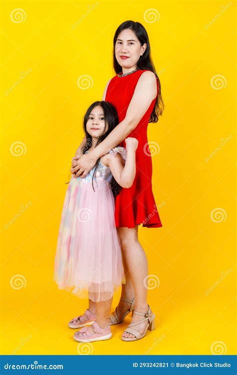 Asian Mom And Daughter Taking Portrait Photo Together On Yellow