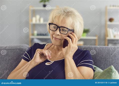 Pensive Mature Woman Talking To Relatives On Mobile Phone Sitting On