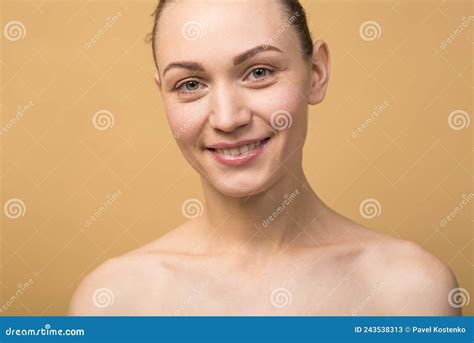 portrait of attractive and happy naked caucasian girl isolated on beige