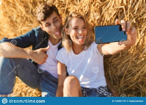 Photo Of Amazing Couple Man And Woman Taking Selfie While Sitting Under