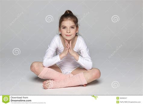 sporty girl sitting on the floor in lotus posture stock