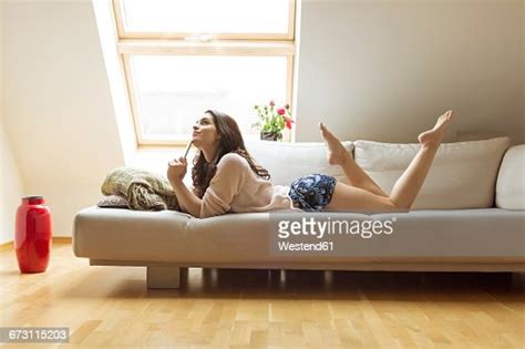 Relaxed Woman Lying On Couch Photo Getty Images
