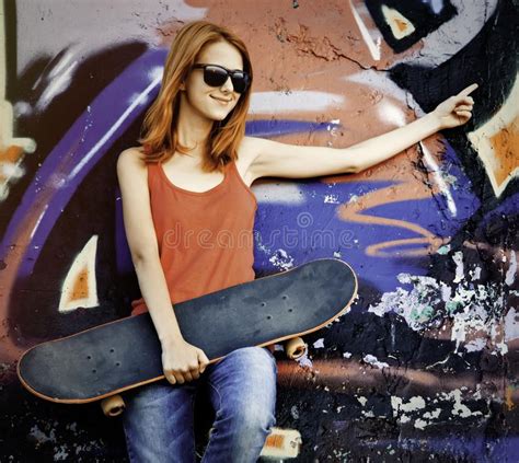 girl with skateboard and sunglasses living an urban