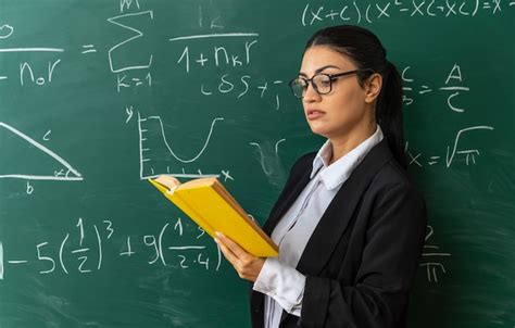 Free Photo Smiling Young Female Teacher Standing In Front Blackboard